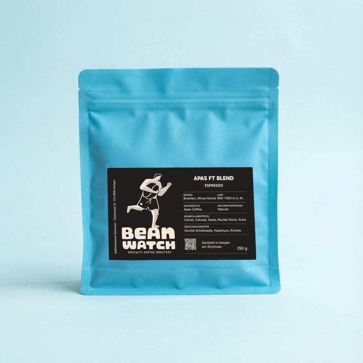 Beanwatch Apas FT Blend Espresso, light blue coffee bag with a dark label and the running lifeguard logo against a light blue studio background