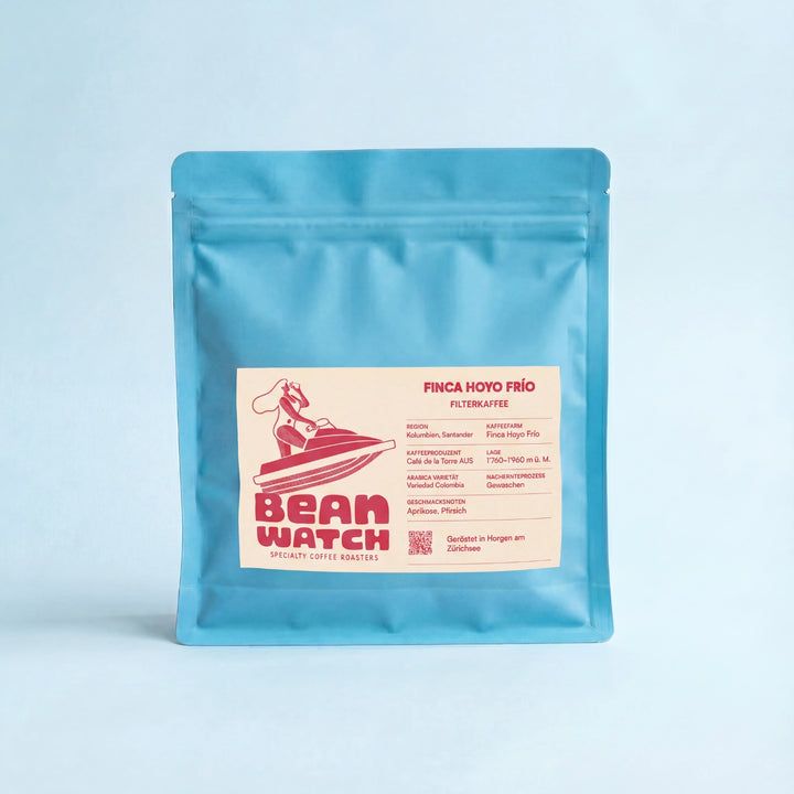Beanwatch Finca Hoyo Frío Filterkaffee, türkise Kaffeepackungen mit pinker Schrift auf hellorangenem Etikett, aus unserer Dragonfruit Pink Linie