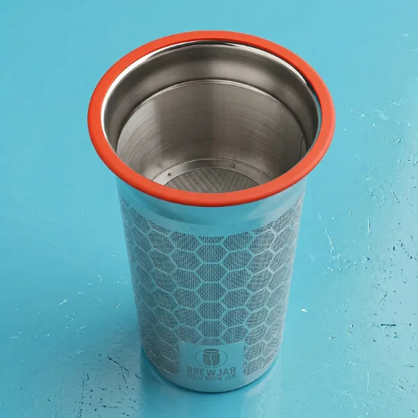 Leeres Cold Brew Sieb aus Edelstahl mit rotem Gummiring auf cyanblau lackierter Oberfläche