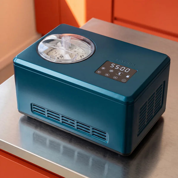 Eine blaue Eismaschine mit Vanilleeis steht auf einer Küchentheke.