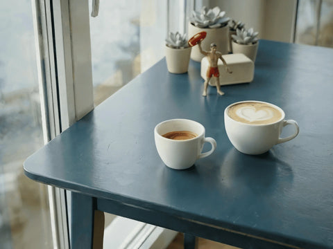 Espresso und Cappuccino Tassen auf einem blauen Tisch